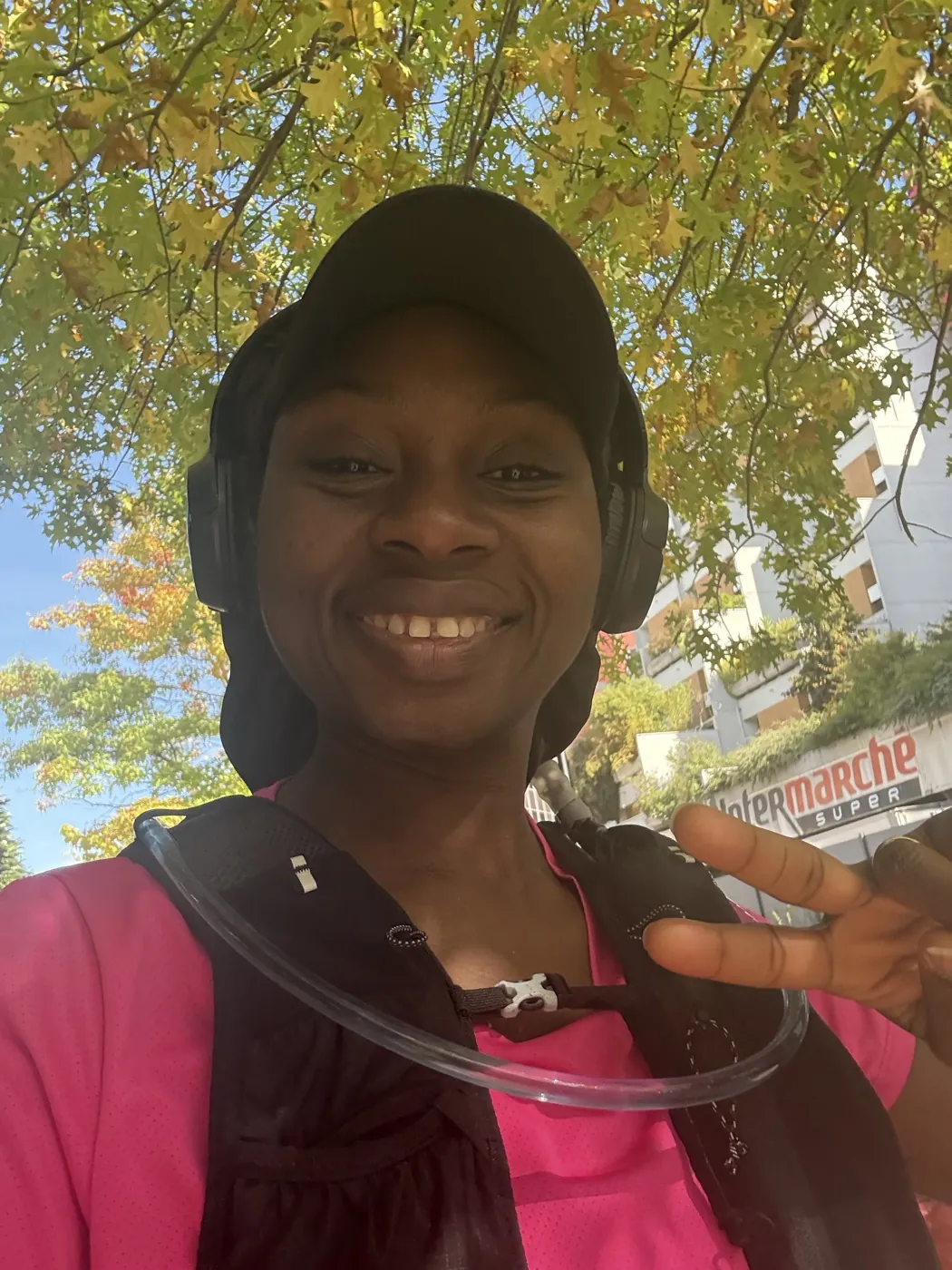 Fatoumata souriante en sortie running d'automne, sac d'hydratation