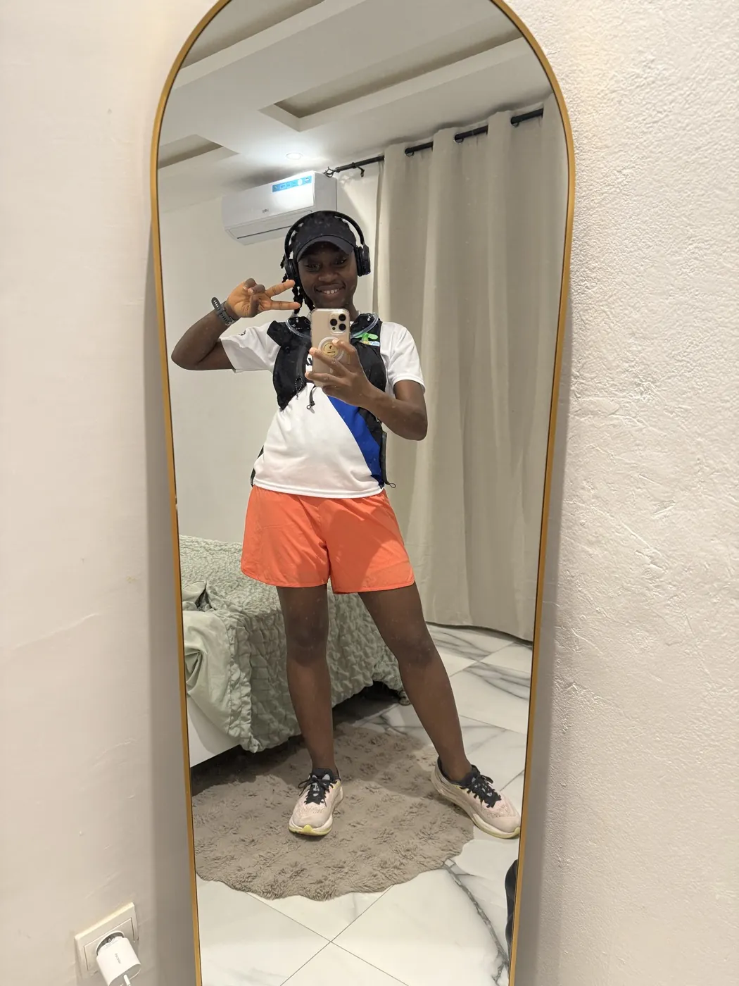 Fatoumata en tenue running complète, miroir, peace sign